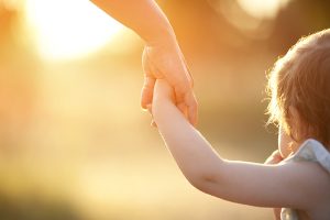 Toddler holding hands with mother