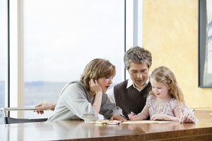 Parents helping their daughter draw