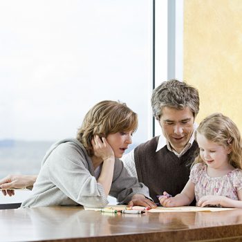 Parents helping their daughter draw