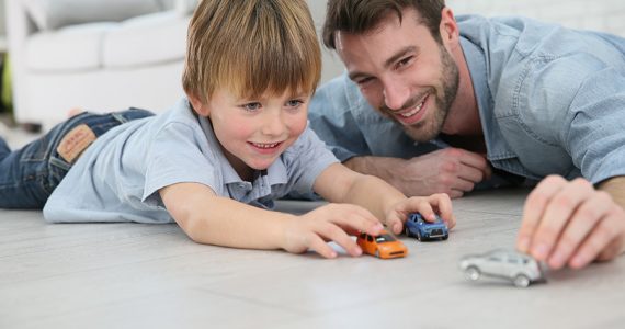 Father with son playing with toy cars