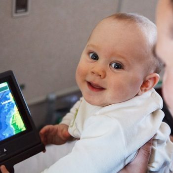 Baby in front of a digital travel screen