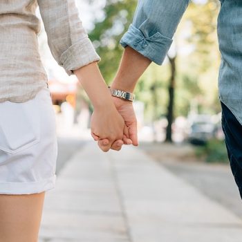 Man and woman holding hands outside