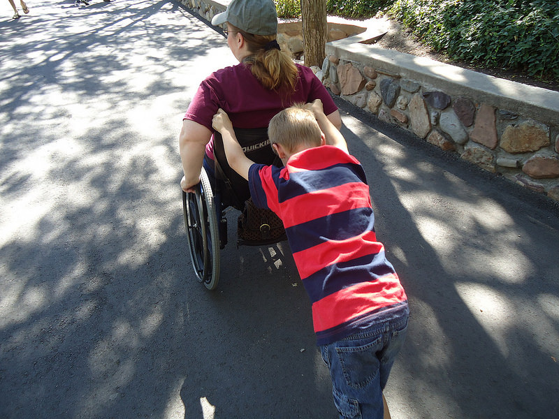 Child pushing woman in wheelchair