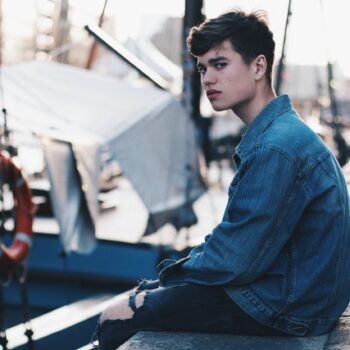 upset boy sitting on dock