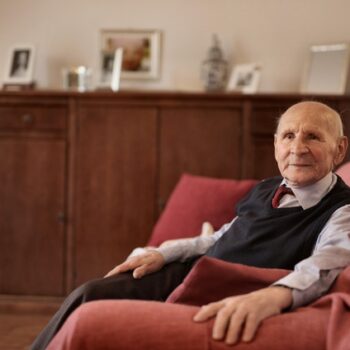 elderly man sitting at home on couch