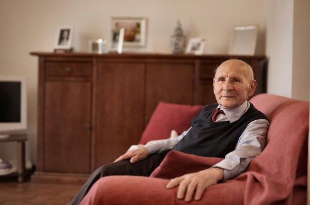 elderly man sitting at home on couch