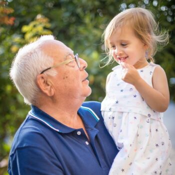 elderly man holding small child