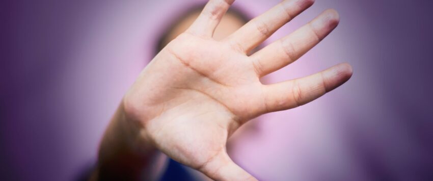 hand signal for stop, faded woman purple background